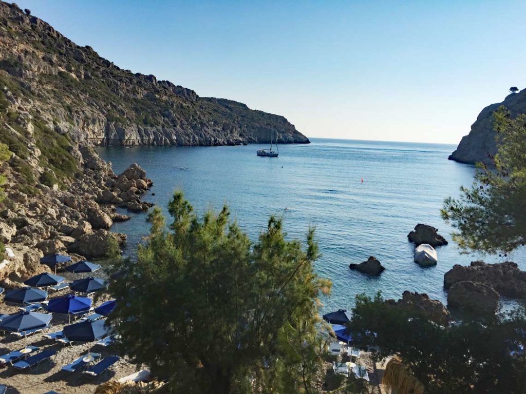 anthony-quinn-bucht-auf-rhodos-felsklippen-zu-beiden-seiten-ruhiges-meer-blaue-liegen-am-strand