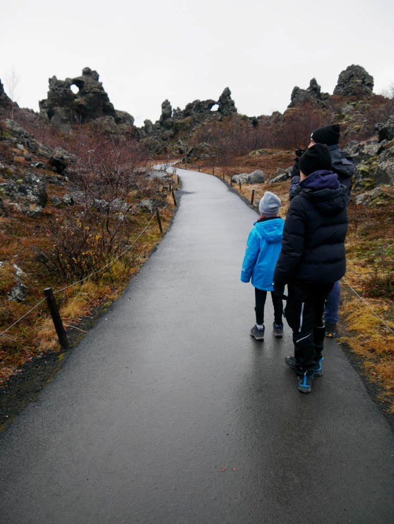 dimmuborgir-lavafeld-zwei-kinder-laufen-auf-geteertem-weg-in-richtung-lavaformationen