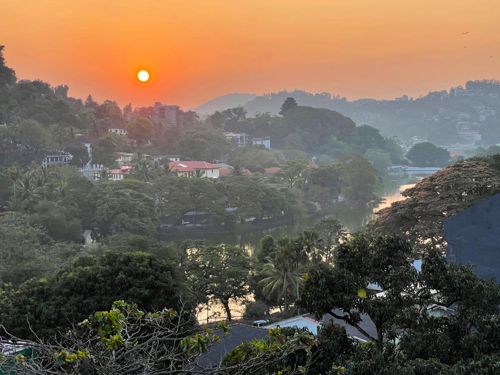 sonnenuntergang-in-kandy-orange-farbener-himmel-ueber-dem-fluss-der-sich-durch-die-stadt-schlaengelt