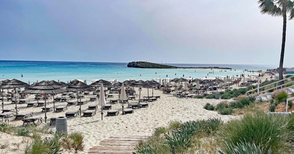 nissi-beach-ayia-napa-strand-mit-liegestuehlen-am-tuerkisen-meer-mit-blick-auf-insel