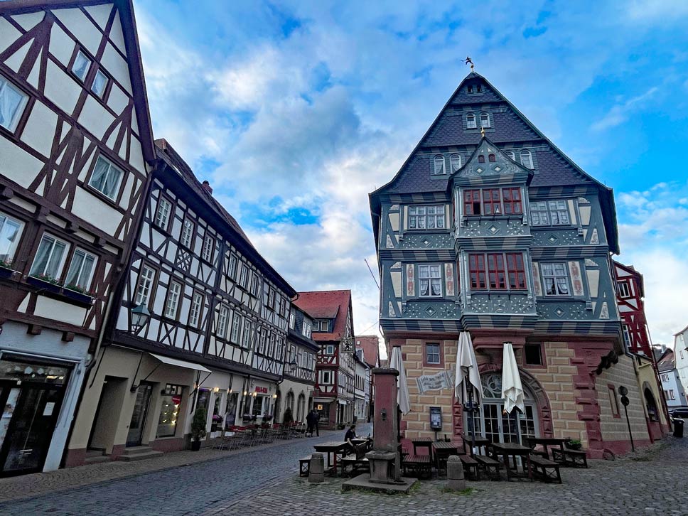 blaues-fachwerkhaus-gasthaus-zum-riesen-in-miltenberg-in-kopfsteinpflastergasse-neben-anderen-fachwerkhaeusern