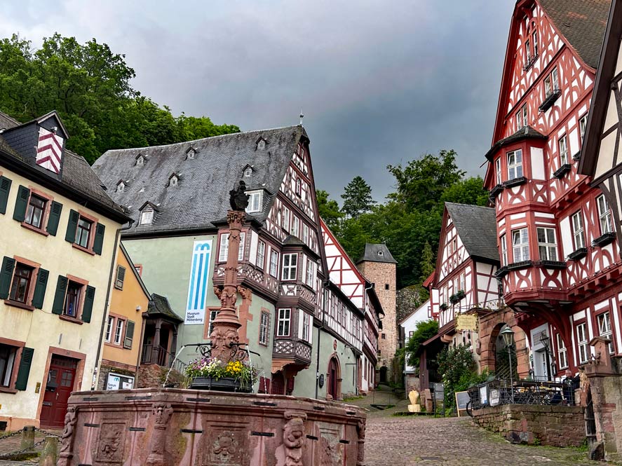 fachwerkhaeuser-auf-marktplatz-mittig-roter-sandsteinbrunnen-in-miltenberg