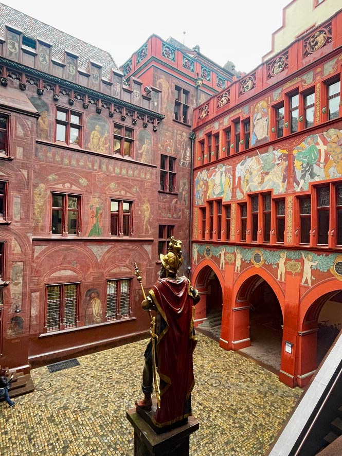 skulptur-vor-roter-sandstein-fassade-mit-wandmalerei-in-basler-rathaus