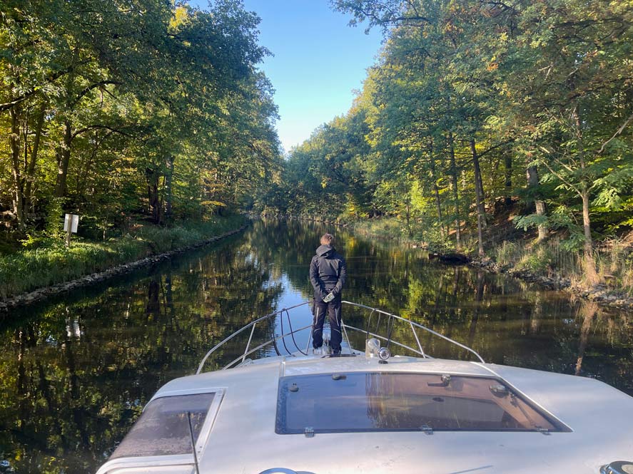 teenager-vorne-auf-hausboot-im-kanal-auf-havel