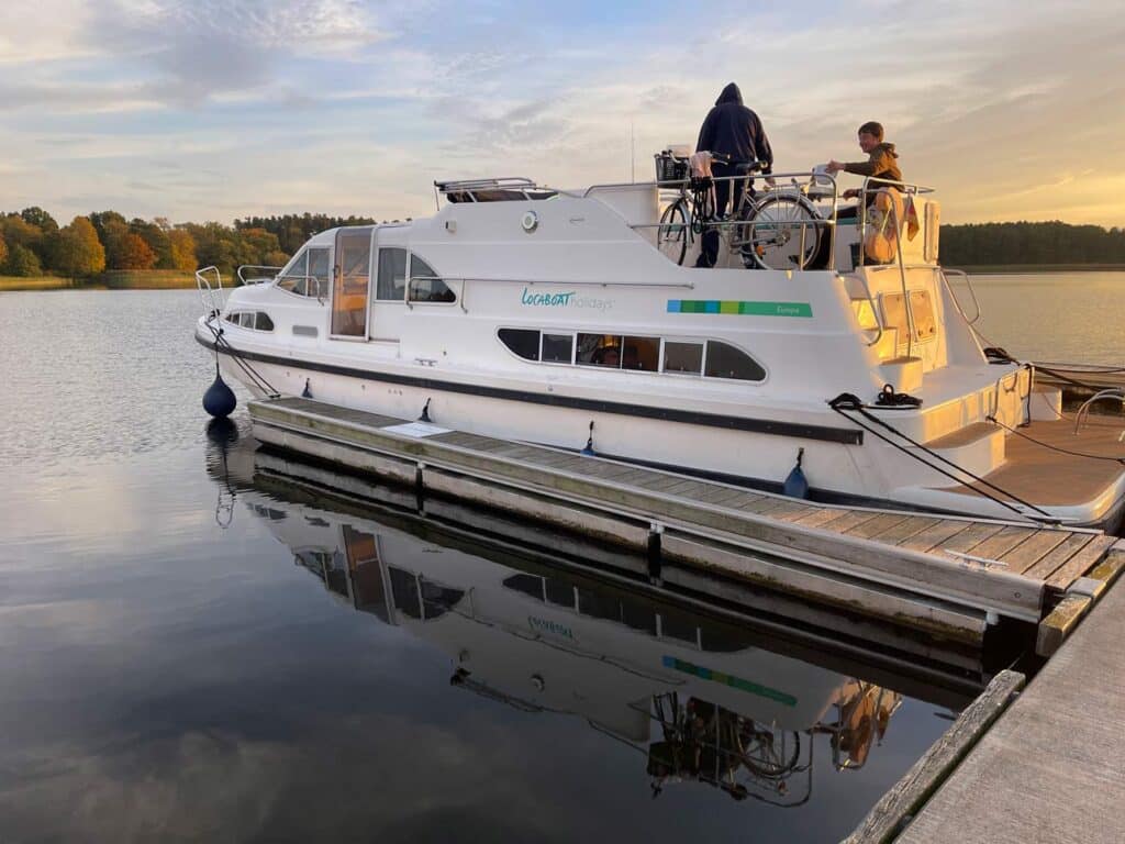 vater-und-sohn-auf-hausboot-im-sonnenuntergang